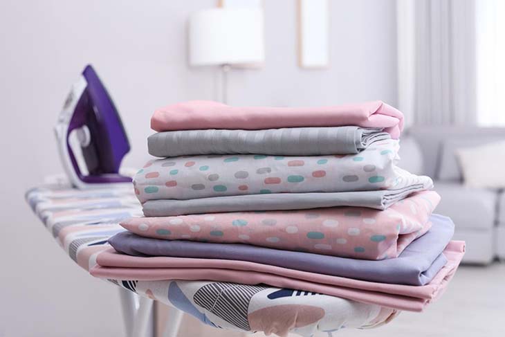 Les draps de lit sur une table à repasser Les draps de lit sur une table à repasser