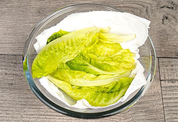 Placez la salade dans un récipient en verre avec du papier absorbant Placez la salade dans un récipient en verre avec du papier absorbant